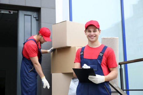 Movers carrying household items through a West Ham property